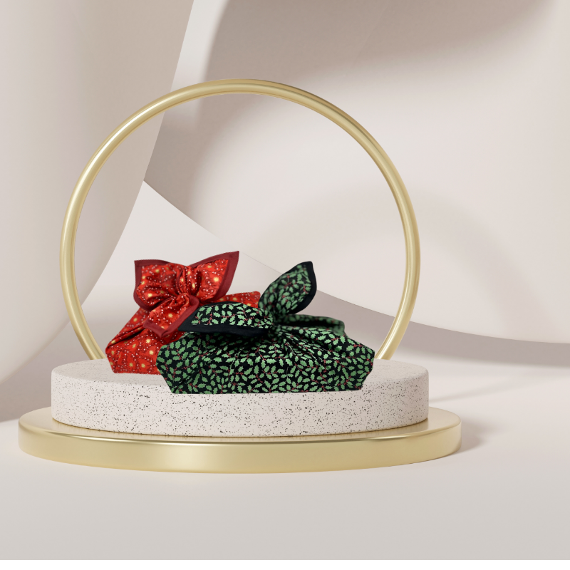 A fabric gift wrap with a Christmas holly pattern, luxury, personalised embroidery, eco friendly 
Next to red fabric gift wrap. Matching set 