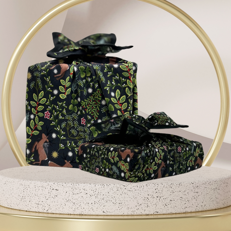 A fabric gift wrap with a festive winter design, featuring reindeer and snowflakes pattern. 
Luxury, eco-friendly, embroidery personalisation 