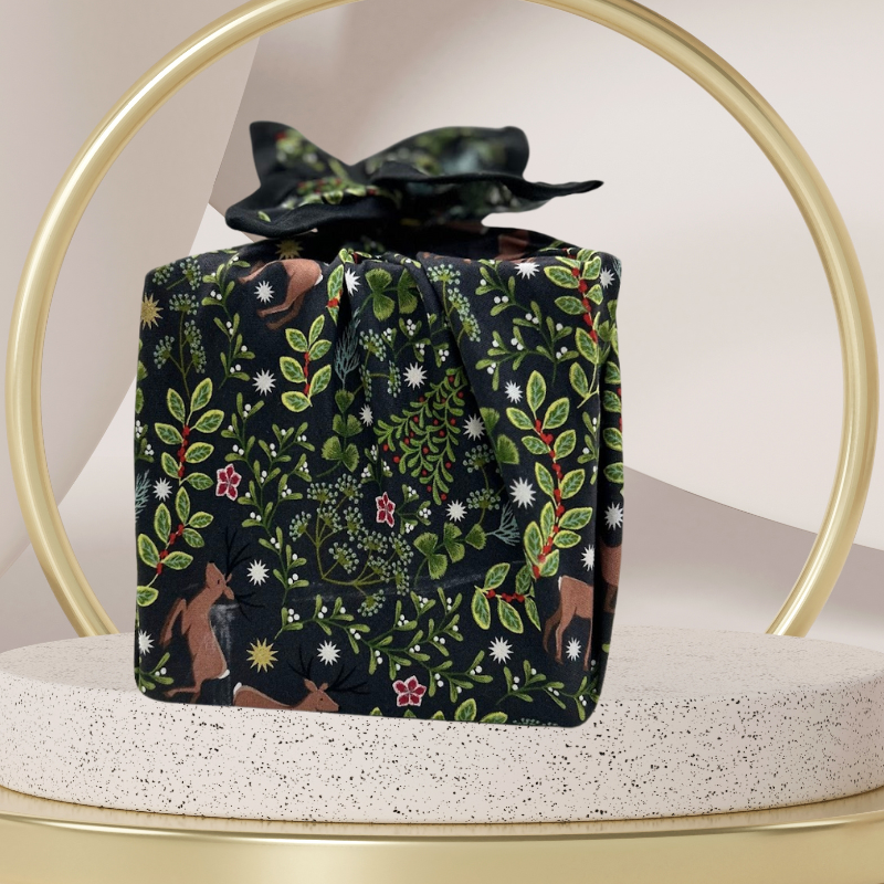 A fabric gift wrap with a festive winter design, featuring reindeer and snowflakes pattern. 
Luxury, eco-friendly, embroidery personalisation 
