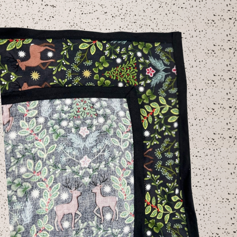 A fabric gift wrap with a festive winter design, featuring reindeer and snowflakes pattern. 
Luxury, eco-friendly, embroidery personalisation 