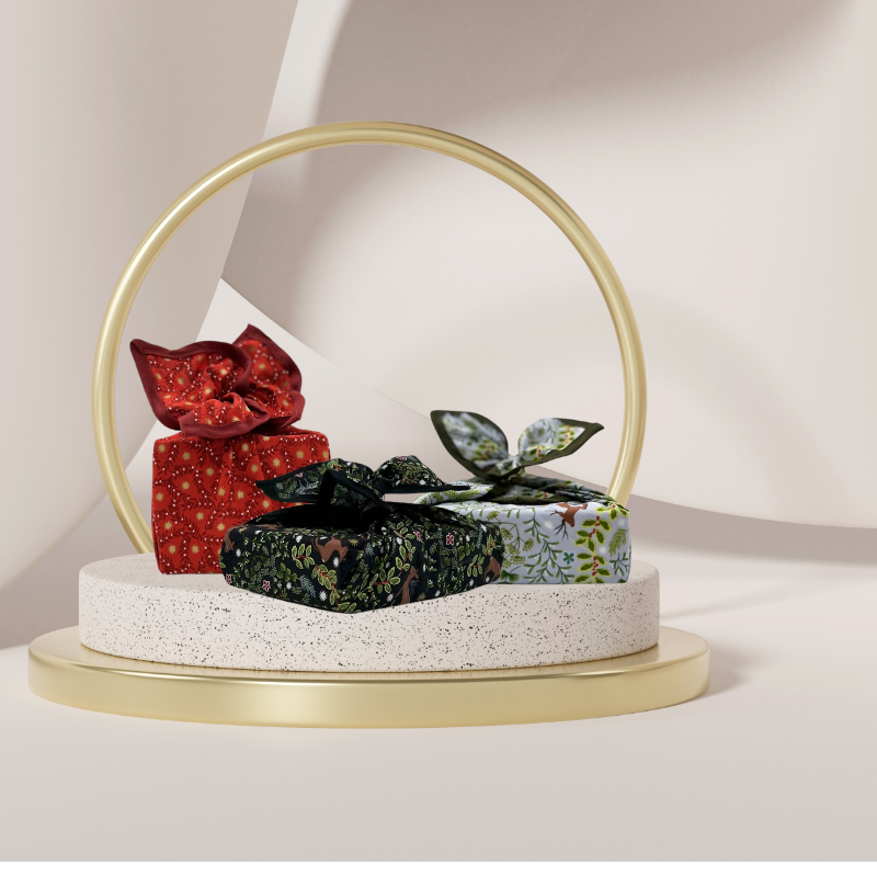 A fabric gift wrap with a festive winter design, featuring reindeer and snowflakes pattern. 
Luxury, eco-friendly, embroidery personalisation 