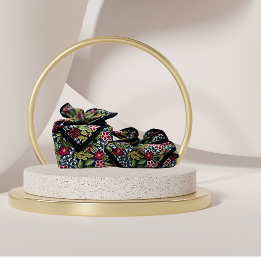 A fabric gift wrap with a floral pattern featuring crimson leaves, winter foliage, and blooming flowers. Luxury, eco-friendly, embroidery personalisation  