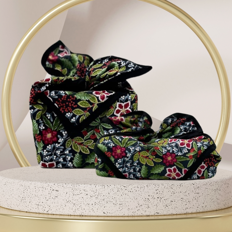 A fabric gift wrap with a floral pattern featuring crimson leaves, winter foliage, and blooming flowers. Luxury, eco-friendly, embroidery personalisation  