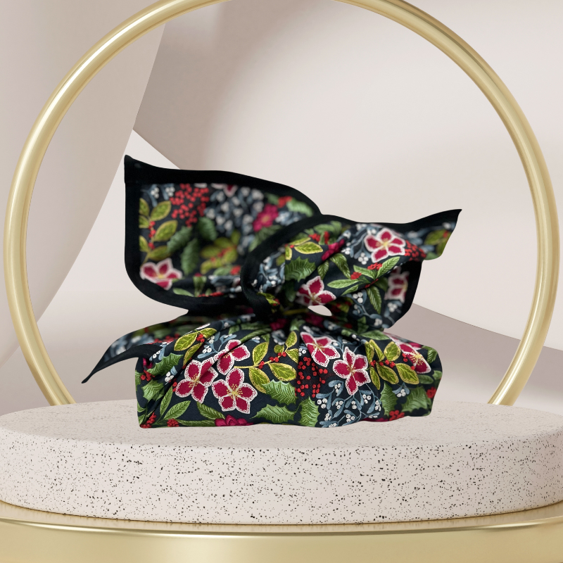 A fabric gift wrap with a floral pattern featuring crimson leaves, winter foliage, and blooming flowers. Luxury, eco-friendly, embroidery personalisation   