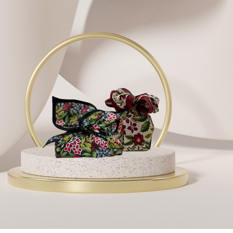 A fabric gift wrap with a floral pattern featuring crimson leaves, winter foliage, and blooming flowers. Luxury, eco-friendly, embroidery personalisation   