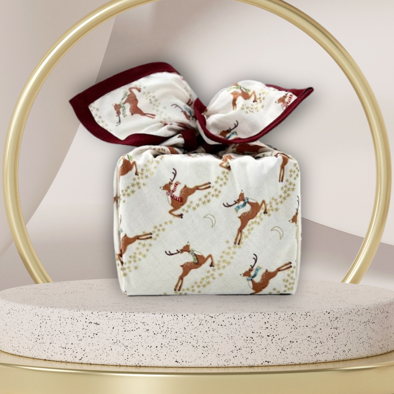 A reusable fabric gift wrap with a reindeer and snow design. Luxury, eco-friendly, embroidery personalisation 