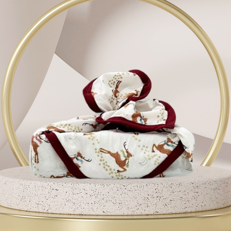 A reusable fabric gift wrap with a reindeer and snow design. Luxury, eco-friendly, embroidery personalisation 