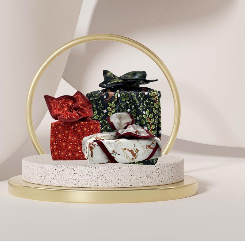 A reusable fabric gift wrap with a reindeer and snow design. Luxury, eco-friendly, embroidery personalisation 