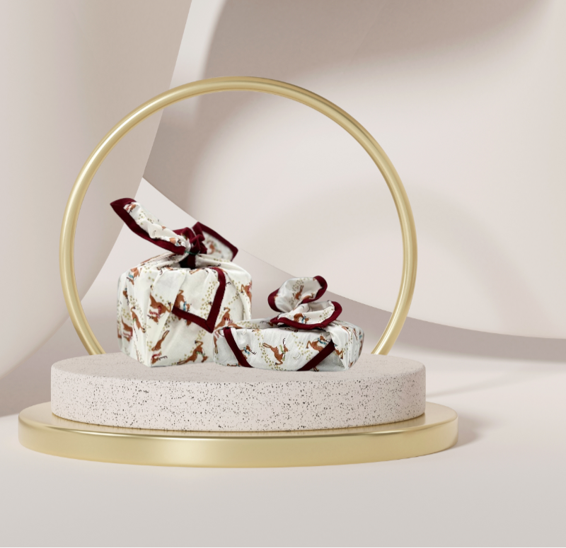 A reusable fabric gift wrap with a reindeer and snow design. Luxury, eco-friendly, embroidery personalisation 