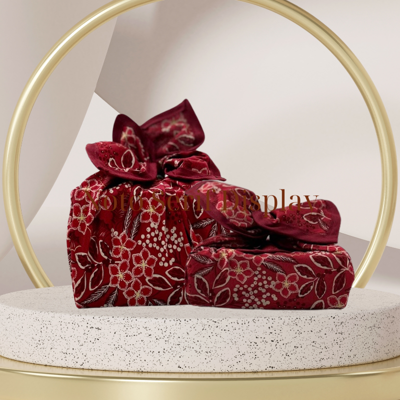 A fabric gift wrap with a Christmas-themed floral pattern, featuring red and green colours and gold accents. Luxury, eco-friendly, embroidery personalisation   